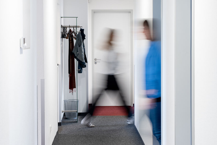 Verschwommenes Bild von Mitarbeitern die durch den Flur gehen